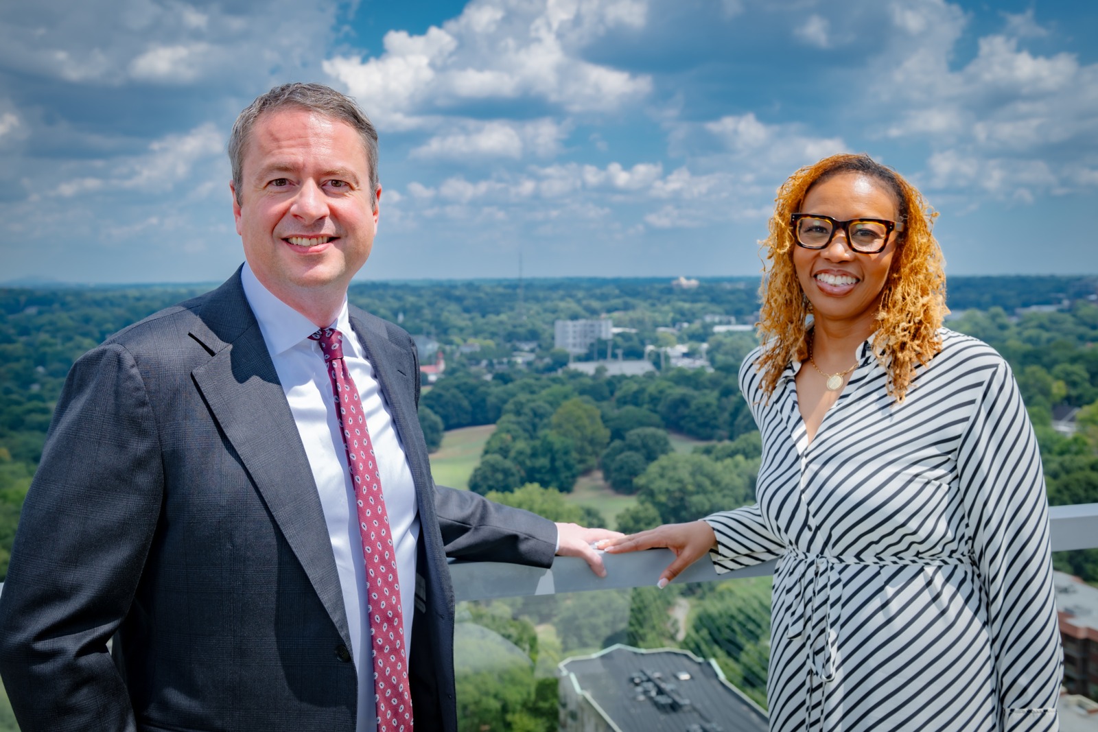 Civil Rights for Civil Servants hosts Shaun Southworth and Lydia Taylor smiling together on a balcony