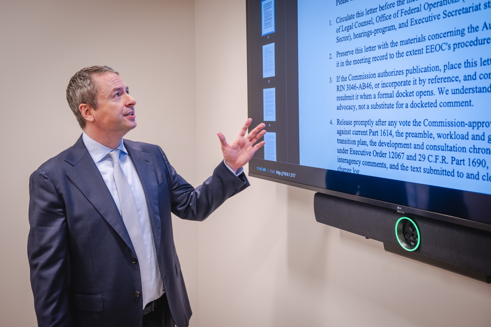 Shaun Southworth explaining a document on a presentation screen with an open-hand gesture